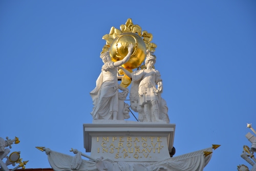 Immagine con oro, bianco, statue, cielo, monumento, sfera, scritta, azzurro, lance, statua, punte, lettere, bandiere, due