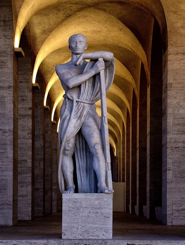 Immagine con statua, archi, luci, marmo, uomo, prospettiva, portici, portico, scultura, pilastri, colonne, bianco, giallo, bastone, braccia, piedistallo