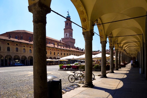 Immagine con colonne, biciclette, portico, piazza, archi, torre, ombre, campanile, porticato, portici, ombra, tende, ombrelloni, prospettiva
