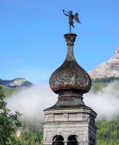 Immagine con angelo, campanile, alberi, tromba, archi, verde, azzurro, cielo, cupola, montagna, montagne, ali, nuvola, cipolla, nuvole, statua, nebbia, bianco, banderuola, rami
