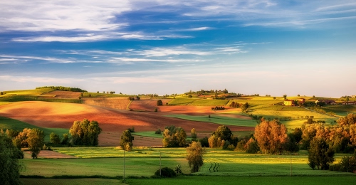 Immagine con alberi, nuvole, colline, cielo, verde, campi, panorama, paesaggio, erba, prati, azzurro, giallo, coltivazioni, autunno, campagna, case, arancione