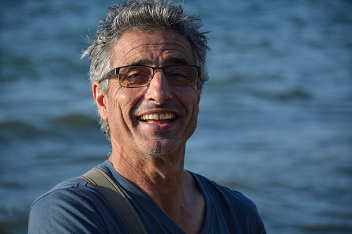 Immagine con occhiali, ritratto, sorriso, capelli, denti, uomo, azzurro, mare, naso, rughe, occhi, acqua, sfocato, grigio, grigi, orecchie, riso, maglietta