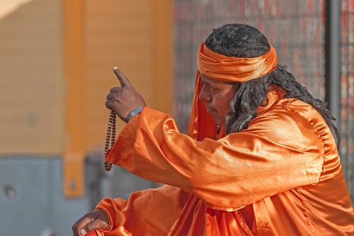 Immagine con arancione, capelli, uomo, collana, dito, santone, artista, mani, fascia, arancio, persona