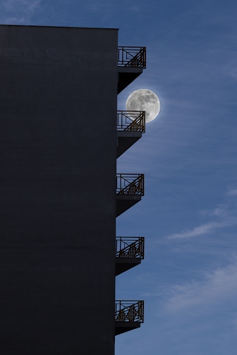 Immagine con luna, cielo, balconi, palazzo, nuvole, ringhiere, azzurro, blu, edificio, casa, piena, sera