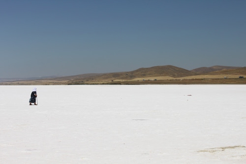 Immagine con deserto, bianco, cielo, colline, donna, montagne, persona, sabbia, sale, azzurro, solitudine, bastone, solo, neve, orizzonte, passante, camminare