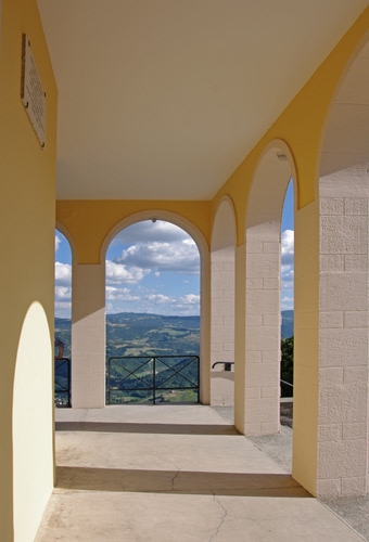 Immagine con archi, nuvole, cielo, panorama, ringhiera, portico, ombre, affaccio, pilastri, colonne, paesaggio, bianco, ombra, montagne, lapide