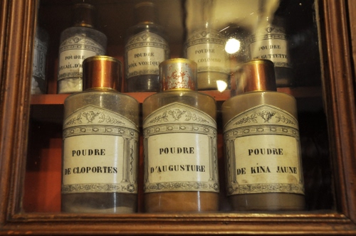 Immagine con vetrina, bottiglie, legno, vetro, tappi, polvere, barattoli, etichette, contenitori, riflesso