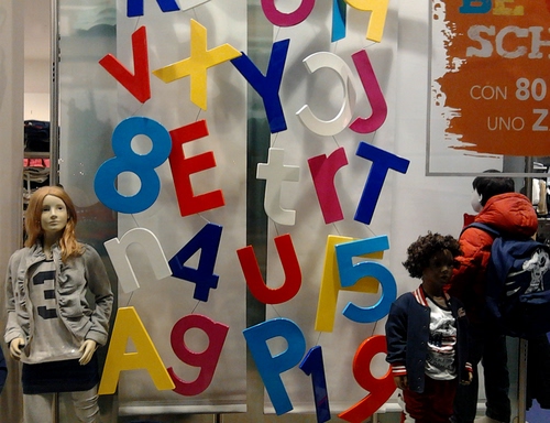Immagine con lettere, numeri, vetrina, manichini, colori, manichino, vestiti, negozio