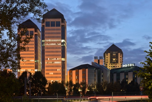 Immagine con luci, nuvole, cielo, finestre, grattacieli, alberi, insegna, grattacielo, palazzi, edifici, sera, rami, hotel, torri