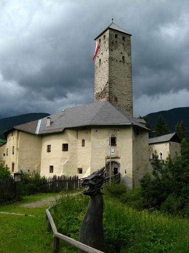 Immagine con torre, castello, bandiera, drago, nuvole, verde, legno, cielo, statua, scultura