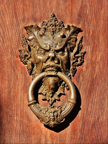 Immagine con legno, batacchio, denti, anello, metallo, occhi, porta, battente, bocca, mascherone, venature, battiporta, cerchio, faccia