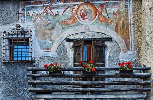 Immagine con balcone, gerani, fiori, finestra, vasi, murales, legno, grata, affresco