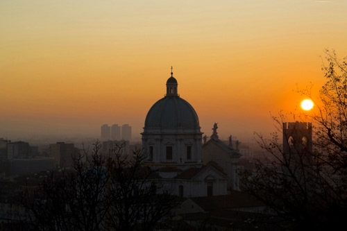 Immagine con cupola, tramonto, chiesa, sole, rosso, torre, foschia, croce, panorama, cielo