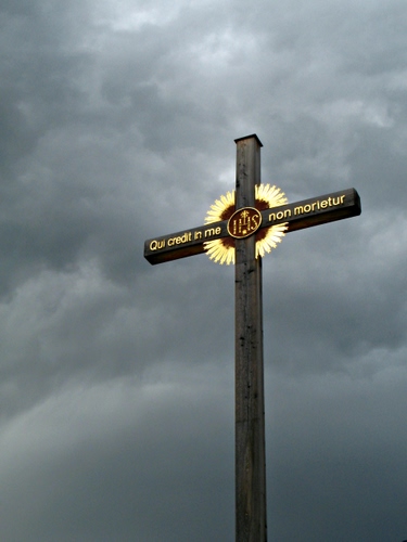 Immagine con croce, legno, oro, nuvole, scritta, cielo, grigio