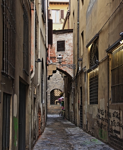 Immagine con vicolo, lampione, bicicletta, finestre, arco, inferriate, grate, stretto