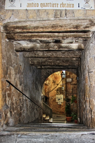 Immagine con vicolo, gradini, lampione, scale, scala, legno, arco, corrimano, travi, passamano, vasi, scalini, scalinata, scorcio