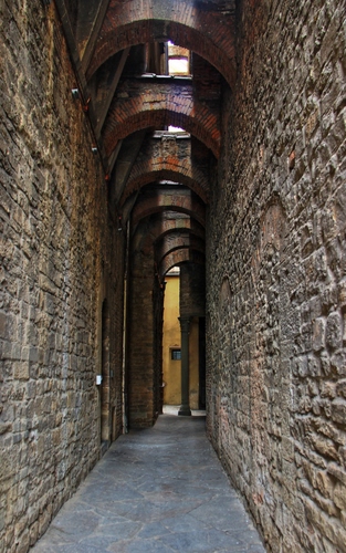 Immagine con vicolo, archi, colonna, pietra, muri, sassi, contrafforti, arcate, mattoni, stretto