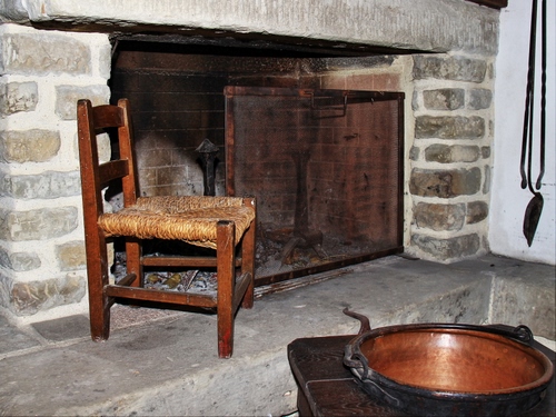 Immagine con sedia, camino, pietre, pentola, paiolo, paglia, pietra, alari, muro, tegame, rame