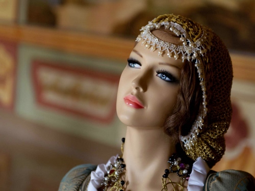 Immagine con occhi, donna, perle, manichino, viso, bambola, cappello, labbra, sguardo, gioielli, bocca, naso, sfocato, volto, azzurro, capelli, corona