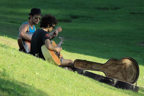 Immagine con chitarre, prato, erba, verde, cappello, occhiali, custodia, musica, due, musicisti, chitarristi, uomini, seduti, ombra, suonare, ragazzi, chitarra, strumenti