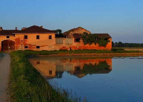 Immagine con acqua, riflesso, erba, verde, cascina, strada, lago, cielo, casa, alberi, finestre, casolare, tetto, azzurro