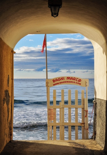 Immagine con mare, bandiera, acqua, onde, arco, cancello, nuvole, cielo, spiaggia, bagni, lampione
