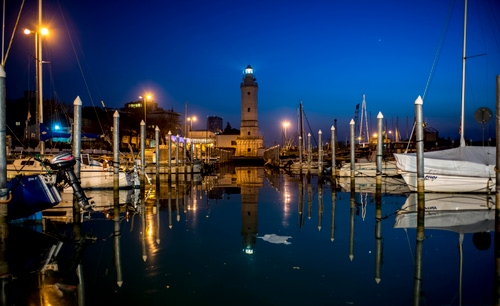 Immagine con barche, faro, porto, riflesso, acqua, luci, notte, canale, luce, notturno