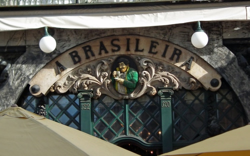 Immagine con insegna, lampioni, numeri, scritta, verde, tenda, caffè, ombrelloni