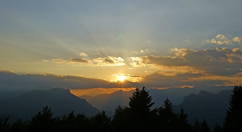 Immagine con tramonto, nuvole, sole, alberi, montagne, controluce, cielo