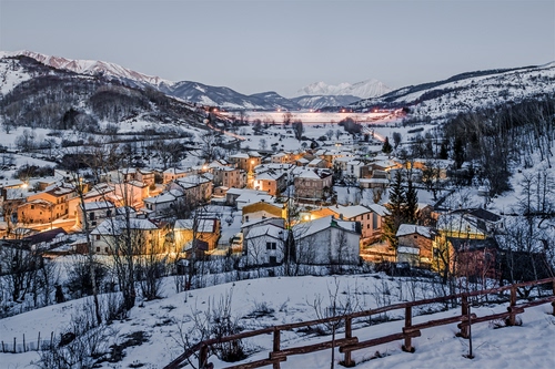 Immagine con neve, staccionata, luci, inverno, montagna, montagne, panorama, case, paese, paesaggio, borgo, alberi, freddo, tetti, villaggio, cielo