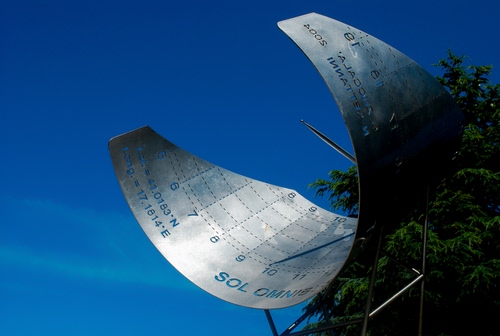 Immagine con meridiana, numeri, cielo, orologio, azzurro, alberi, acciaio, gnomone, albero, scritte