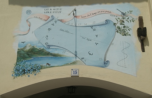 Immagine con numero, meridiana, muro, tempo, disegno, parete, arco, ombra, murales, fiori, zodiaco, orologio, numeri, quindici, azzurro, civico, scritte, segni