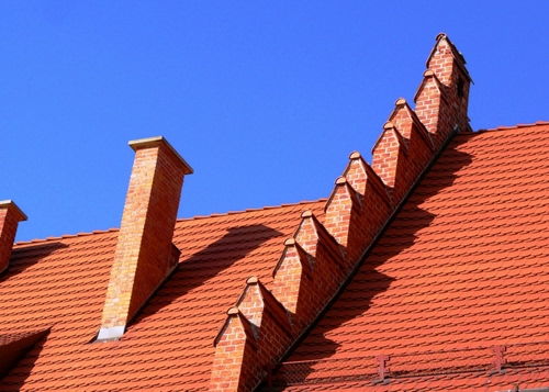 Immagine con tetto, tegole, cielo, comignoli, camini, rosso, ombra, azzurro