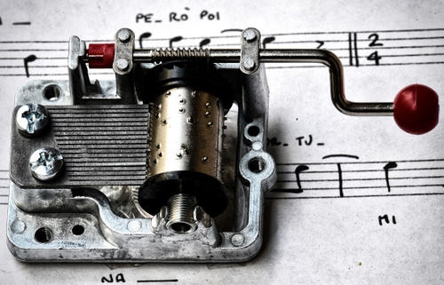 Immagine con musica, carillon, note, manovella, pentagramma, spartito, righi