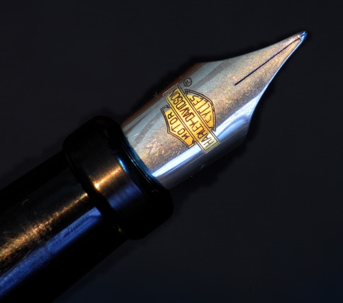 Immagine con penna, pennino, stilografica, marchio, punta, nero, inchiostro, acciaio, metallo