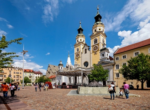 Immagine con piazza, chiesa, persone, campanili, alberi, passanti, nuvole, cielo, fontana