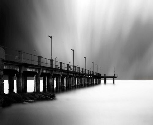 Immagine con lampioni, pontile, cielo, bianconero, mare, acqua, nuvole, nebbia, ringhiera, ponte, colonne, luce, molo