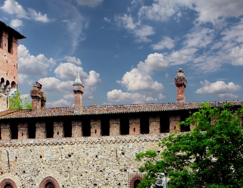 Immagine con nuvole, tetto, comignoli, cielo, verde, finestre, albero, castello, azzurro, tre, torre, alberi, pianta, foglie, archi