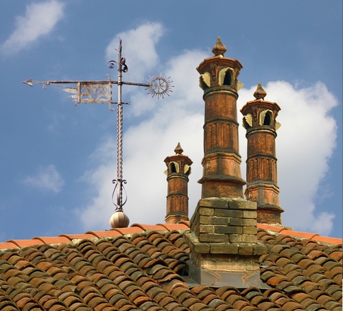 Immagine con tegole, tetto, comignoli, nuvole, tre, cielo, mattoni, camini, freccia