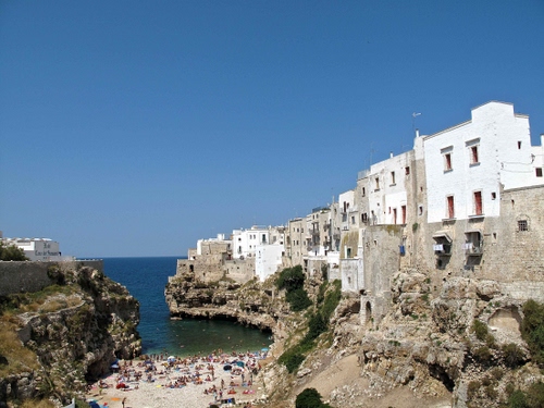 Immagine con mare, spiaggia, case, insenatura, cielo, finestre, scogli, bagnanti, acqua, azzurro, borgo, puglia, bianco, paese, scogliera