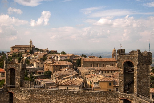 Immagine con tetti, case, campanili, nuvole, torri, torre, cielo, città, mura, panorama, alberi, finestre, affaccio, chiese, campanile, mattoni, camminamento, borgo
