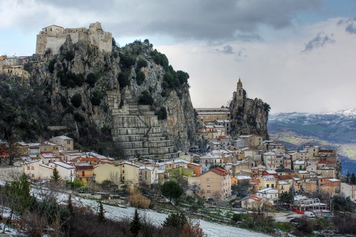 Immagine con case, montagna, borgo, panorama, castello, paese, roccia, cielo, campanile, alberi, rocce, nuvole, neve