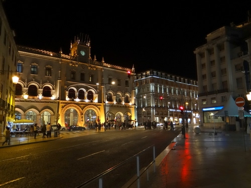 Immagine con strada, notte, luci, palazzi, piazza, orologio, semaforo, persone, passanti, notturno