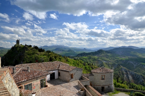 Immagine con nuvole, montagne, torre, panorama, cielo, borgo, colline, tetti, case, porte, verde, paesaggio, finestre