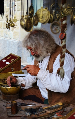 Immagine con artigiano, mani, uomo, martello, attrezzi, incisore, treccia, capelli, cesellatore