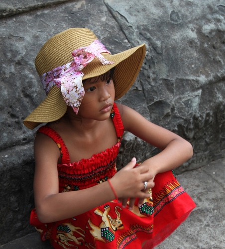 Immagine con cappello, rosso, bambina, vestito, paglia, nastro, anello, mani, rosa, braccialetto, fiocco, muro