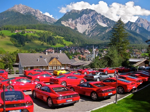 Immagine con ferrari, rosso, montagna, montagne, nuvole, auto, automobili, rosse, macchine, panorama, case