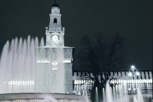 Immagine con fontana, orologio, acqua, torre, lampione, albero, castello, notte, luci, notturno, fontane, spruzzi, zampilli, campanile, alberi