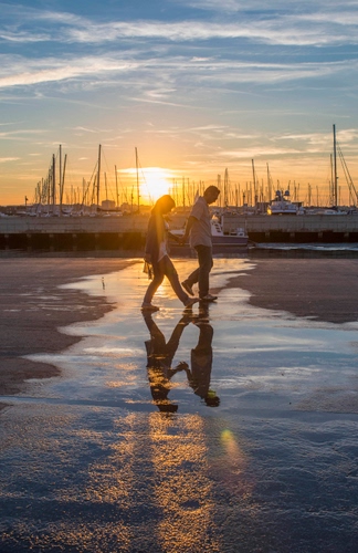 Immagine con barche, sole, tramonto, riflesso, cielo, porto, due, passanti, nuvole, controluce, acqua, persone, alberi, pozzanghera, riflessi
