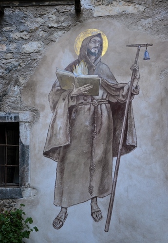 Immagine con murales, santo, libro, aureola, finestra, muro, campanella, saio, bastone, dipinto, grata, casa, sandali, frate, pittura